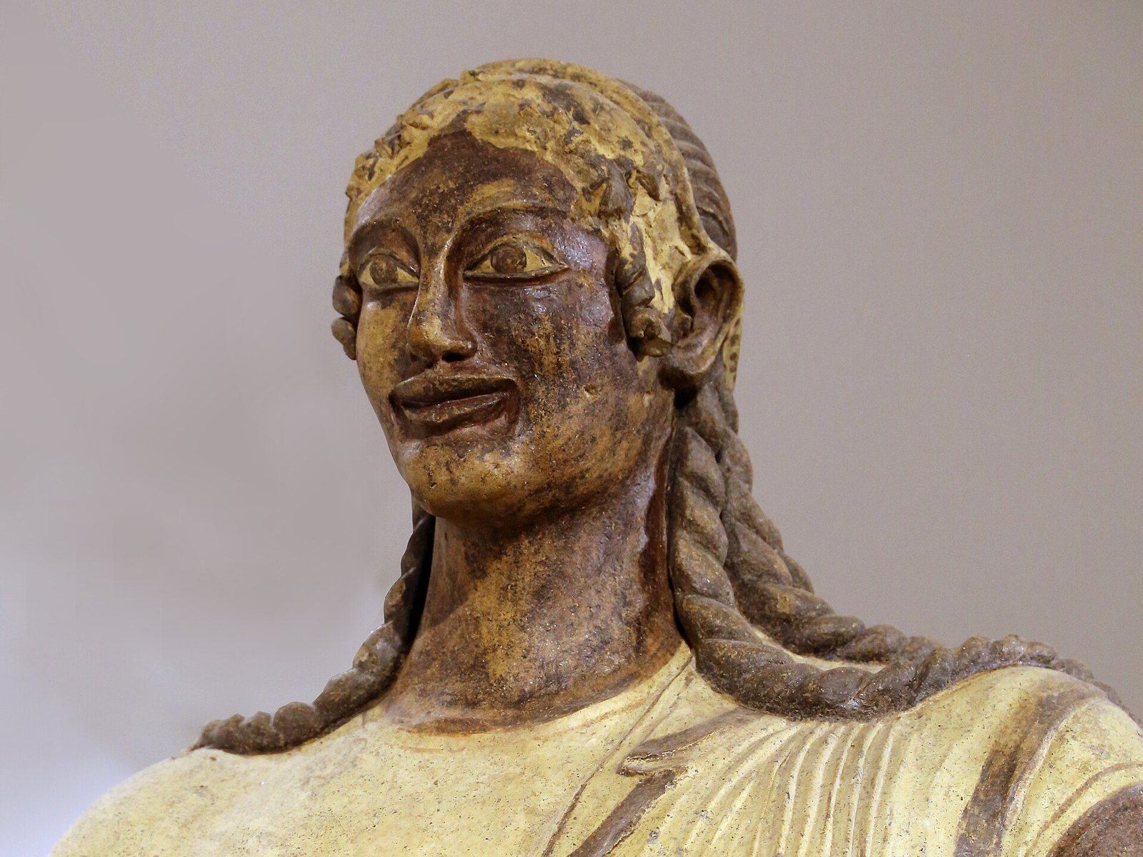 Il volto sorridente dell'Apollo di Veio, statua etrusca in terracotta dipinta del santuario di Portonaccio