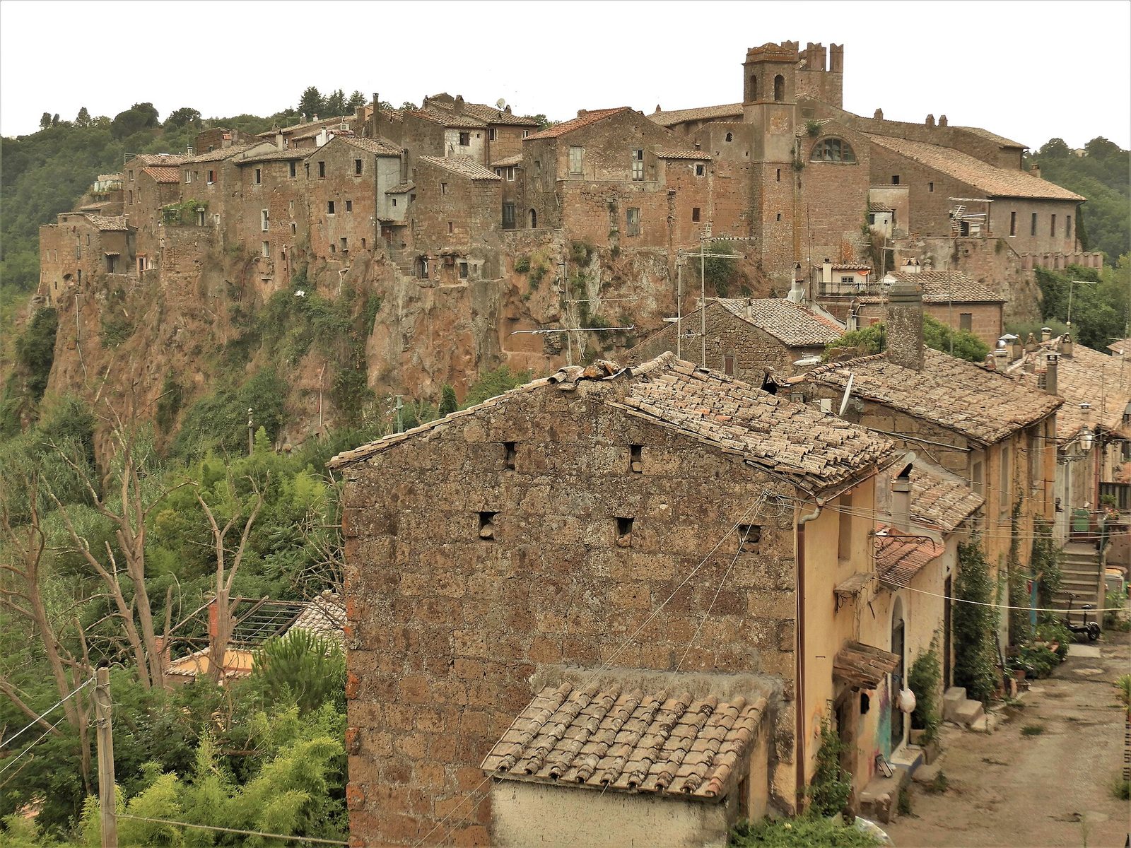 Le case di Calcata arroccate sulla rupe di tufo, con il torrione e tetti in coppi in primo piano