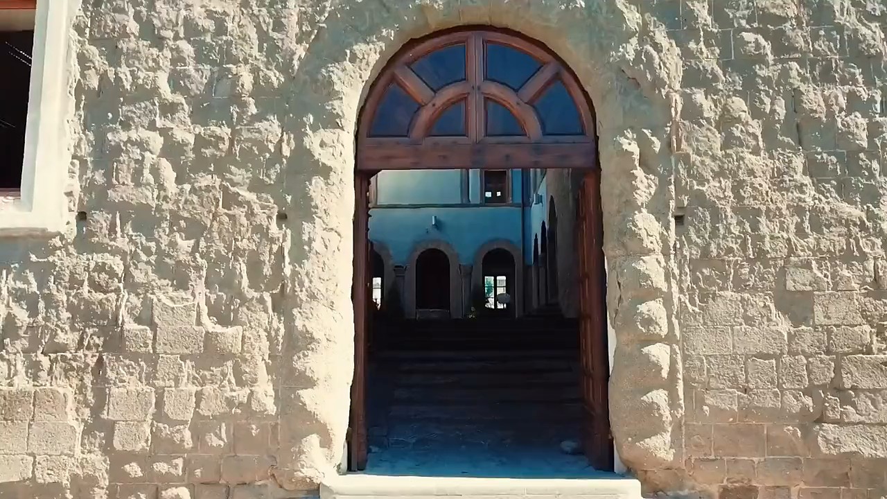 Il portale ad arco nel muro di pietra di Palazzo Chigi, aperto sul cortile