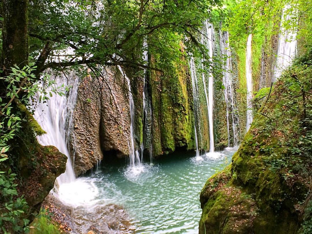 Una cascata del Fosso della Mola nella Valle del Sorbo: veli d'acqua sulla parete di roccia coperta di muschio e una pozza verde